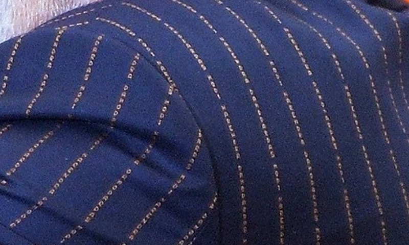 A close up shot of the pinstripe suit worn by Prime Minister Modi with his name woven into it. -AFP