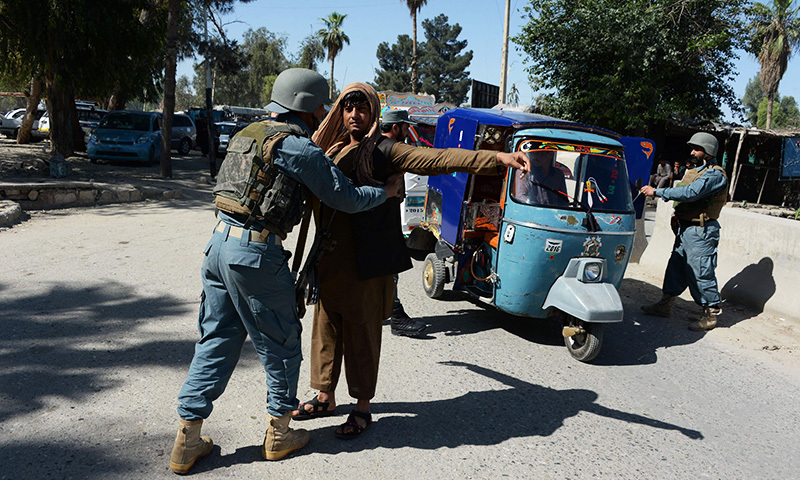 An Afghan policeman searches a passenger in the city of Jalalabad, close to the border with Pakistan, on April 29, 2016, after reports that an aid worker from Perth has been kidnapped by armed men in Jalalabad. -AFP