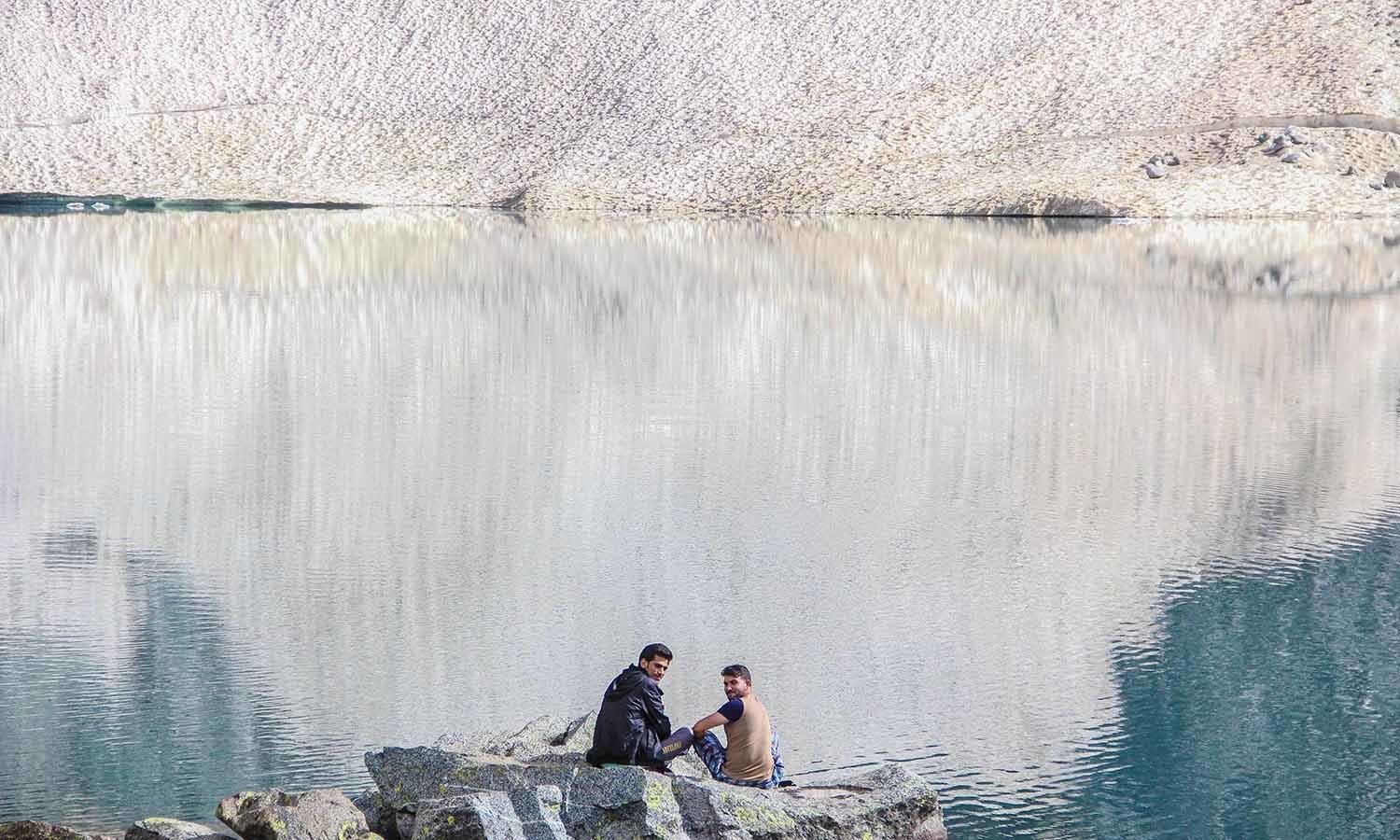 The hard trek is worth the views at the glacial lake. Trekkers rest at the edge of Bishigram Lake