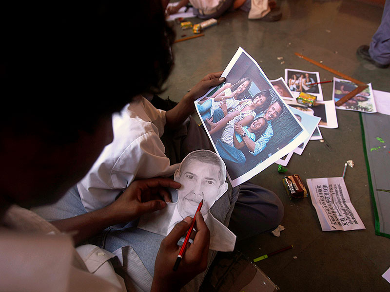 A school boy makes a sketch of President Barack Obama as another holds his family photograph at the Holy Name school in Mumbai. Students of this school are gearing up to celebrate Diwali festival with President Obama during his visit later this week.