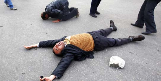 A protester pleads to God to "liberate Egypt from Mubarak" as another prays during a demonstration in Tahrir square in Cairo