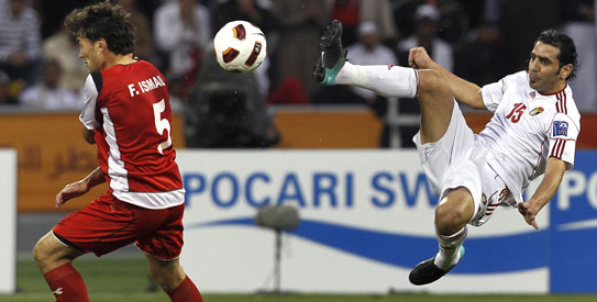 Syria's Feras Ismail, fights for the ball with Jordan's player Shadi Abu Hashhash. —AP Photo