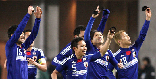 Japanese national team members raise their black band after scoring a goal against J-league select team during a charity match to raise money for victims of the earthquake and tsunami disasterat at the Nagai stadium in Osaka. —Photo by AFP