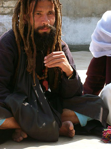 A malang sitting in the courtyard of the shrine. Malangs are disciples of saints who have given up worldly pleasures for inner spirituality. They often play music and dance outside shrines.