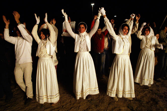 Joyful Iranian Zoroastrian young people join hands and clap, as they celebrate their ancient mid-winter Sadeh festival, outside the capital Tehran, Iran, Monday, January 30, 2012, after setting a giant bonfire.