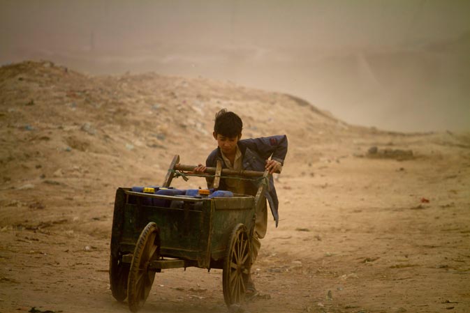 A boy from Pakistan's Mohamand tribal region pushes a handcart loaded with water containers as he heads home during a dust-storm at a slum on the outskirts of Islamabad, Pakistan, Monday, March 12, 2012. ?
AP Photo