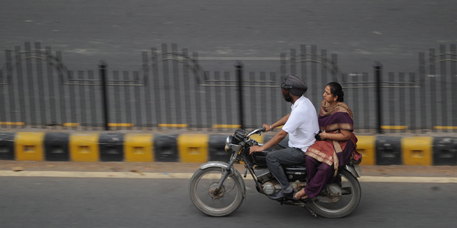 helmet-india660 A woman rides on the back of a motorbike in Delhi on April 10, 2012. While the law mandates a helmet for her male driver, a woman can legally go without. Campaigners are becoming increasingly vocal about the consequences of this anomaly which results in dozens of lives needlessly lost each year as well as thousands of serious injuries that wreck families and burden hospitals. AFP PHOTO/PRAKASH SINGH
