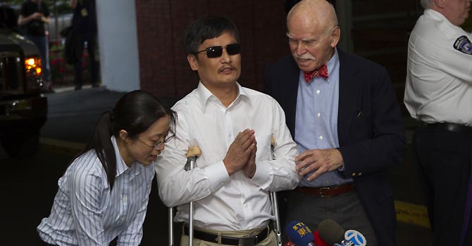Blind Chinese dissident Chen Guangcheng (C) speaks to members of the media after arriving in New York May 19, 2012. Chen arrived in the United States on Saturday after China allowed him to leave a hospital in Beijing in a move that could signal the end of a diplomatic rift between the two countries.  REUTERS/Keith Bedford (UNITED STATES - Tags: POLITICS MEDIA)