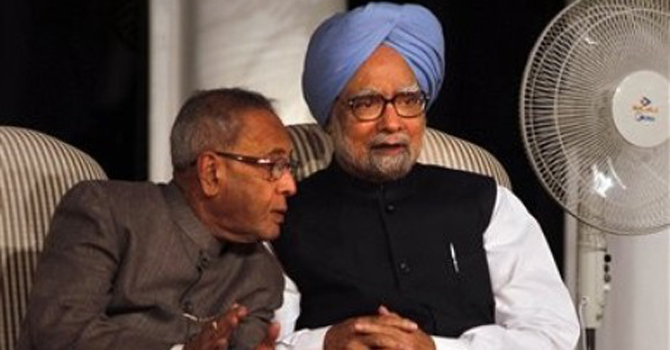 Indian Prime Minister Manmohan Singh, blue-turban, listens to Finance Minister Pranab Mukherjee.—File Photo