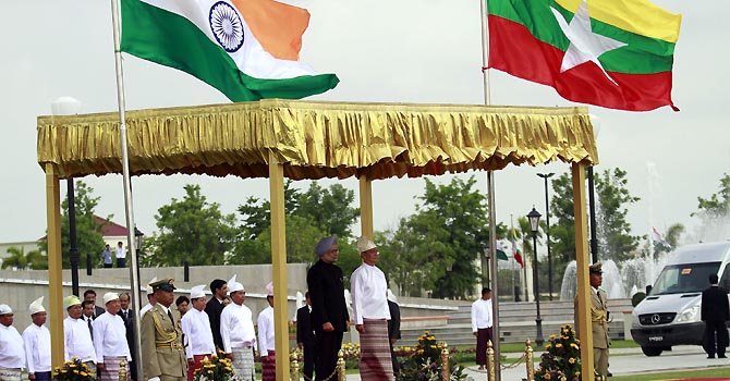 Myanmar President Thein Sein, right on the stage, and Indian Prime Minister Manmohan Singh, left on the stage, review an honor guard before their meeting at presidential house in Naypyitaw, Myanmar Monday, May 28, 2012. (AP Photo/Khin Maung Win)