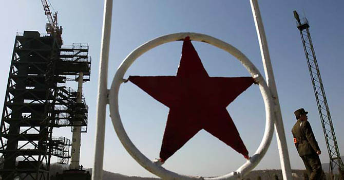 A soldier stands guard in front of the Unha-3 (Milky Way 3) rocket sitting on a launch pad at the West Sea Satellite Launch Site, during a guided media tour by North Korean authorities in the northwest of Pyongyang in this April 8, 2012 file photo. North Korea's much hyped long-range rocket apparently crashed into the sea a few minutes after launch on April 13, 2012, South Korean and other officials said, dealing a blow to the prestige of the reclusive and impoverished state. REUTERS/Bobby Yip/Files (NORTH KOREA - Tags: MILITARY POLITICS SCIENCE TECHNOLOGY)