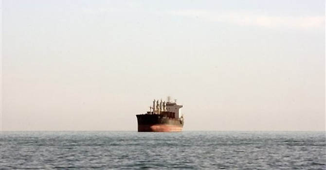 A cargo ship is seen between Iranian city port of Bandar Abbas and Qeshm island in the strategic water way of Persian Gulf, on Friday, Dec. 23, 2011. (AP Photo/Vahid Salemi)