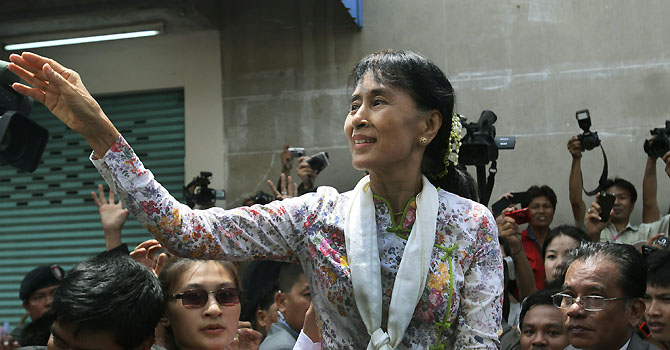 Myanmar opposition leader Aung San Suu Kyi waves to the crowd while leaving a community center in Mahachai, Samut Sakhon Province, Thailand on Wednesday, May 30, 2012. Kicking off her first trip abroad in nearly a quarter-century, Suu Kyi offered encouragement Wednesday to impoverished Myanmar migrants whose flight to neighboring Thailand is emblematic of the devastation wrought on her homeland by decades of misrule.(AP photo/Sakchai Lalit)