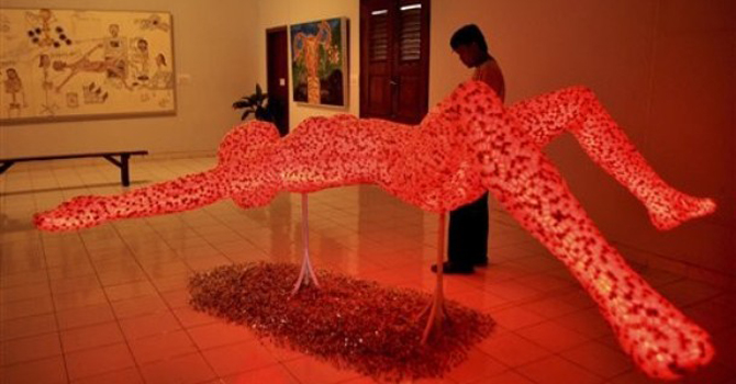 A visitor to an exhibiton looks at a sculpture made of 10,000 used bottles of hormones for in vitro fertilization, created by Indonesian physician Dr. Aucky Hinting, in Yogyakarta, Central Java, Indonesia. – Reuters 