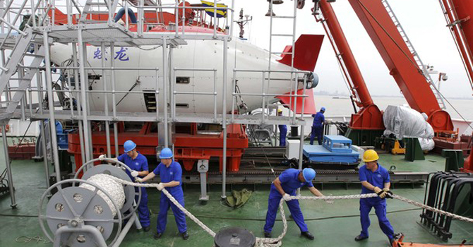 Staff work on a boat in front of the China's manned deep-diving submersible in Jiangyin Staff work on a boat in front of the China's manned deep-diving submersible "Jiaolong" in Jiangyin, Jiangsu. – Reuters