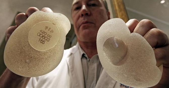Plastic surgeon Denis Boucq poses with silicone gel breast implants manufactured by French company Poly Implant Prothese (PIP) in a clinic in Nice. – Reuters 