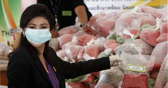 Thailand's Prime Minister Yingluck Shinawatra holds bags of methamphetamine during the 41th Destruction of Confiscated Narcotics ceremony. – Reuters  