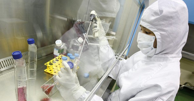 A researcher controls medium for culturing stem cells during a photo call at an aseptic room of the FCB-Pharmicell laboratory in Seongnam, near Seoul. – Reuters 