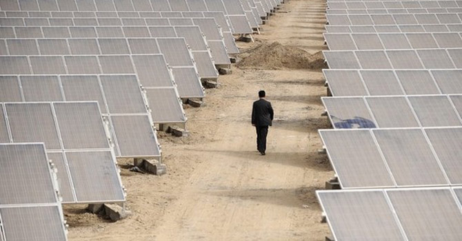 A-man-walks-through-solar-panels-at-a-solar-power-plant-under-construction670 A man walks through solar panels at a solar power plant under construction.—Reuters Photo