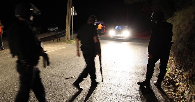 French paramilitary control a checkpoint at the entrance to Collobrieres, southeastern France on June 18, 2012. A suspect was arrested during a massive manhunt early on June 18 after a man shot dead two female paramilitary gendarmes with one of their own pistols in a village in southeast France. AFP PHOTO / VALERY HACHE