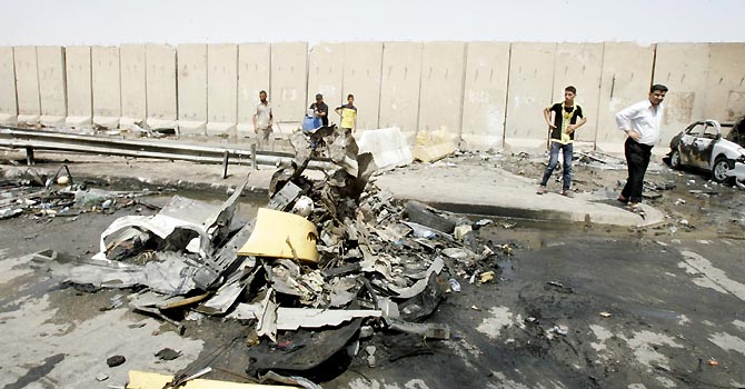 Residents gather at the site of a bomb attack in Baghdad, June 16, 2012. Double car bombs targeting Shi'ite pilgrims in Baghdad killed at least 26 people on Saturday in the latest attacks by insurgents trying to tip Iraq back into widespread sectarian violence. The car bombs exploded near Baghdad's Kadhimiya district, scattering body parts and clothing along a route used by pilgrims marking the anniversary of the death of Shi'ite imam Moussa al-Kadhim, a great-grandson of Prophet Mohammad.  REUTERS