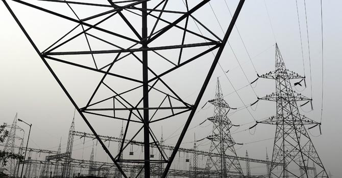 High voltage electricity towers are pictured on the outskirts of New Delhi. — File Photo