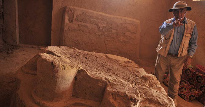 In this picture taken on July 21, 2012, Afghan-born French archaeologist Zemaryalai Tarzi stand next to an archaeological artifact in Bamiyan. 