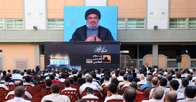 Hezbollah leader Sheikh Hassan Nasrallah speaks through a video link on the occasion of Jerusalem Day in the southern suburb of Beirut, Lebanon, Friday, Aug 17, 2012. Nasrallah warned Israel that any aggression against Lebanon would be extremely costly and said Hezbollah can transform the lives of millions of Zionists in all of Israel to hell. (AP Photo/Bilal Hussein)