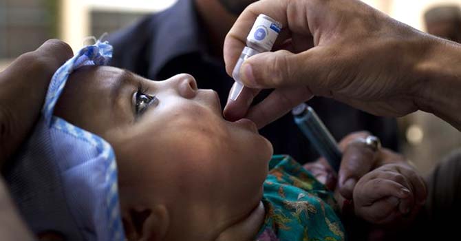 A Pakistani child is given a polio vaccination by a district health team worker outside a children's hospital in Peshawar. – File photo by AP