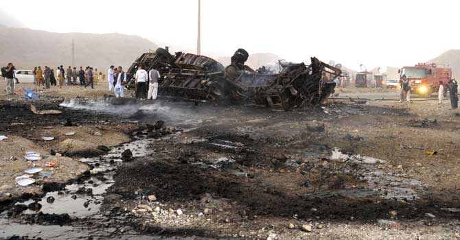 Volunteers search for blast victims in the wreckage of a destroyed passenger bus following a bomb explosion in Mastung district, about 25 kilometres south of Quetta. – Photo by AFP