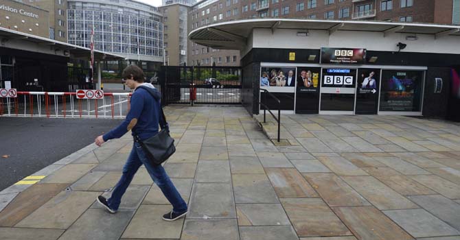 A man walks past BBC television studios in White City in west London October 22, 2012.  Pressure on the BBC to address allegations its bosses covered up sexual abuse claims levelled at one of its former TV stars mounted on Monday after British Prime Minister David Cameron said the broadcaster had serious questions to answer.    REUTERS/Paul Hackett  (BRITAIN - Tags: MEDIA CRIME LAW POLITICS ENTERTAINMENT)