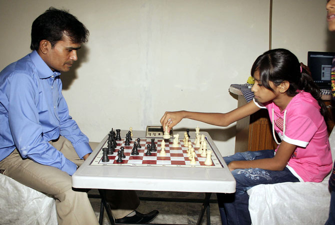 Mahk, age 12 is now the youngest record holder in setting a chessboard in 15 seconds. Guinness Book of World Record team witnessed the event at Expo Center (File photo playing with father). - Photo by INP