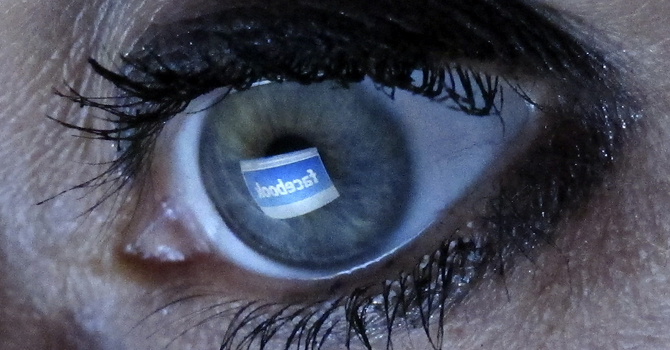 File illustration picture shows a woman looking at the Facebook website on a computer in Munich