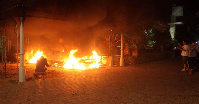 This file photo taken on September 11, 2012 shows a vehicle and the surrounding area engulfed in flames after it was set on fire inside the US mission compound in Benghazi. - AFP Photo