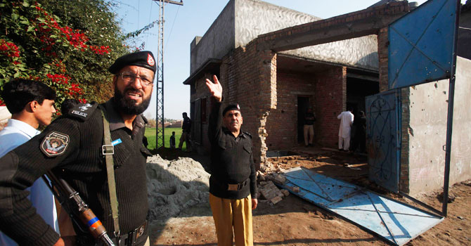 Security force officers are seen near the house where Taliban militants took refuge during a gun battle in Peshawar December 16, 2012. - Photo by Reuters