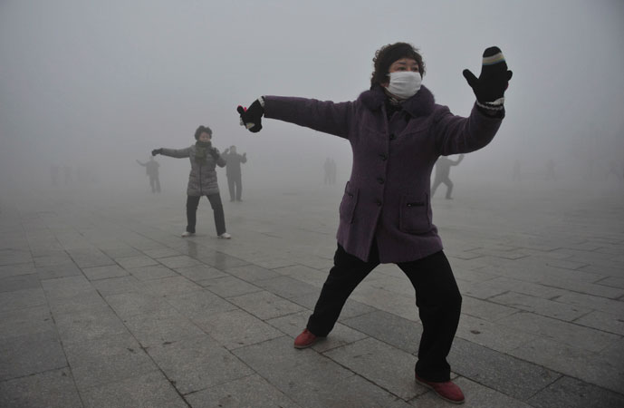 A woman wears a mask as she does her morning exercise outdoors in Fuyang, Anhui province. China's environmental watchdog ordered greater efforts to issue early warnings for air quality on Monday, as hazardous air pollution has hit many parts of the country in recent days, Xinhua News Agency reported. ?Photo by Reuters