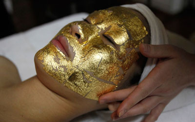 Woman puts on a gold-leaves mask, another facial treatment that also utilises gold. —Photo by Reuters