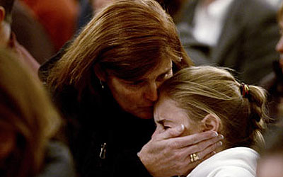 A mother consoles her grieving child at a memorial service for victims of the school shooting in Newtown, Connecticut. —Photo (File) Reuters