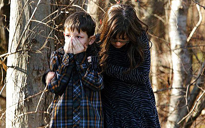 Young children wait outside Sandy Hook Elementary School after the shooting. —Photo (File) Reuters