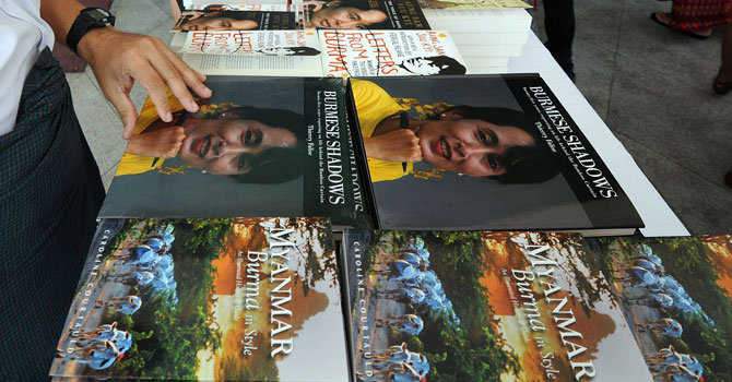 Visitors browse books on sale at a stand outside a hotel hosting Myanmar's first international literary festival, in Yangon. —Photo by AFP