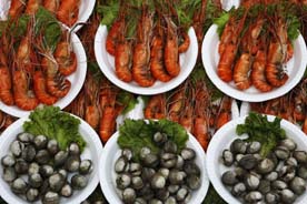 Vendors display seafood from their small boats as tourist visiting the Amphawa floating market at Samut Songkhram province