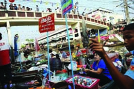 Vendors offer food and drinks from their small boats as tourists visit the Amphawa floating market at Samut Songkhram province