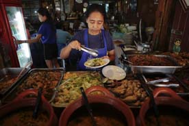 Food is served to customers at a restaurant at the Amphawa floating market at Samut Songkhram province