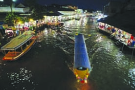 Boats with visitors maneuver through the Amphawa floating market at Samut Songkhram province