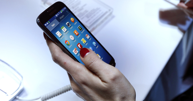 Attendees try out the new Samsung Galaxy S 4 during the Samsung Unpacked event at Radio City Music Hall, Thursday, March 14, 2013 in New York.  (AP Photo/Jason DeCrow)