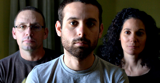 This publicity image released by the TriBeca Film Festival shows Adam Winfield, center, with his parents, Christopher, left, and Emma from "The Kill Team," a film competing in the Tribeca Film Festival. — AP Photo