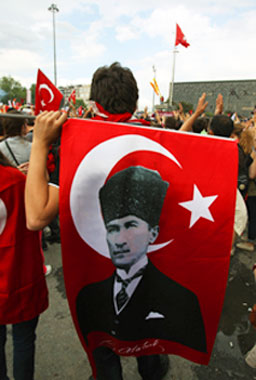 A protester holds a Turkish flag with Mustafa Kemal Ataturk, founder of the Republic of Turkey during the third day of nationwide anti-government protest at the Taskim square in Istanbul, Sunday, June 2, 2013.  – Photo by AP