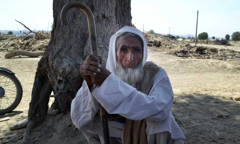 A villager rests under a tree near rubble of destroyed homes following an earthquake in the remote district of Awaran, September 25, 2013. — Photo by AP