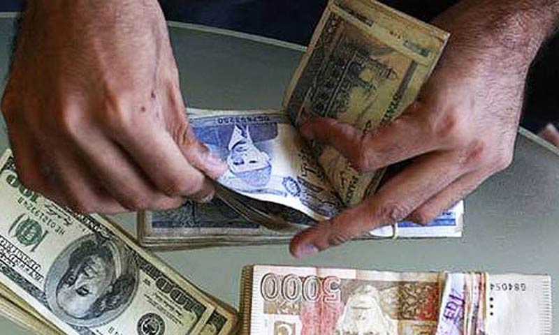 An individual counting a stack of Pakistan Rupees and another stuck of Rupees and US Dollars next to it. This can be used to show the comparison of strength of the two currencies.
