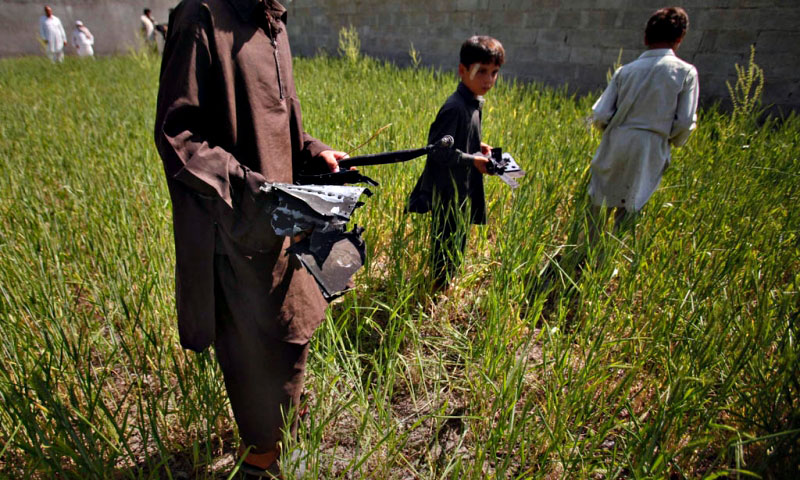 Boys collects debris, remains of a firefight, outside the compound where Al Qaeda leader Osama bin Laden was killed in Abbottabad. —Photo by Reuters